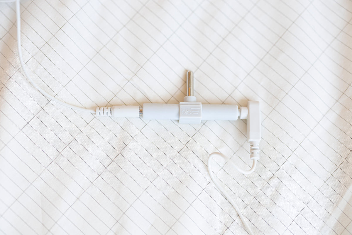 Jordningssplitter och kabel över kanten på ett jordningslakan